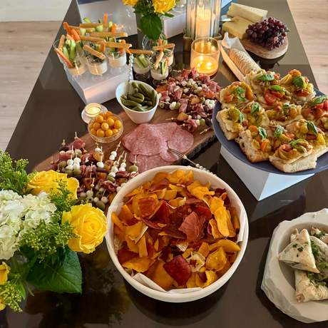 Appetizer spread with bruschetta, crudite cups, and flowers