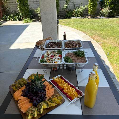Brunch spread with fruit platter and hot trays