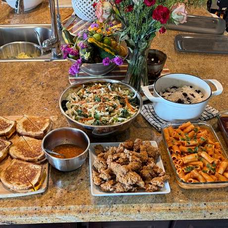 Kitchen counter with grilled cheese, soup, pasta, and salad