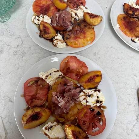 Plated heirloom tomato, peach, and burrata salad